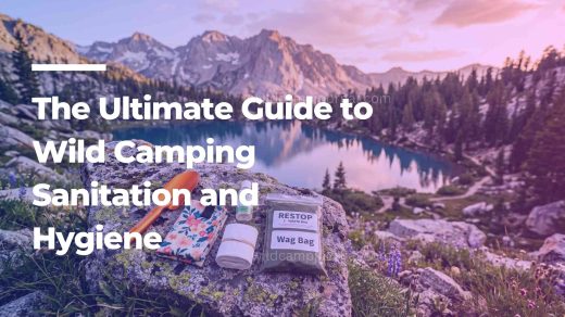 A complete wild camping sanitation kit featuring an ultralight trowel, hand sanitizer, and WAG bag laid out on a rock overlooking a mountain lake.